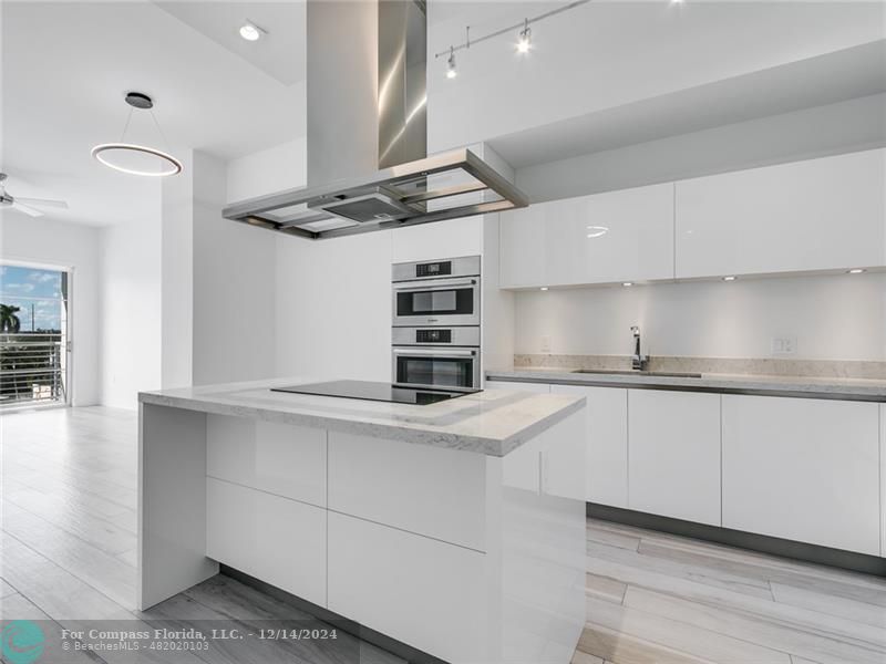 a kitchen with stainless steel appliances cabinets and a wooden floor