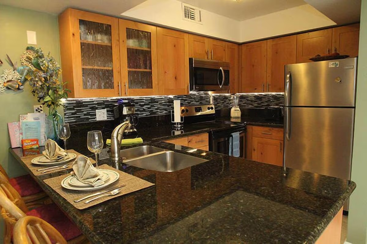 a kitchen with a refrigerator and a stove top oven