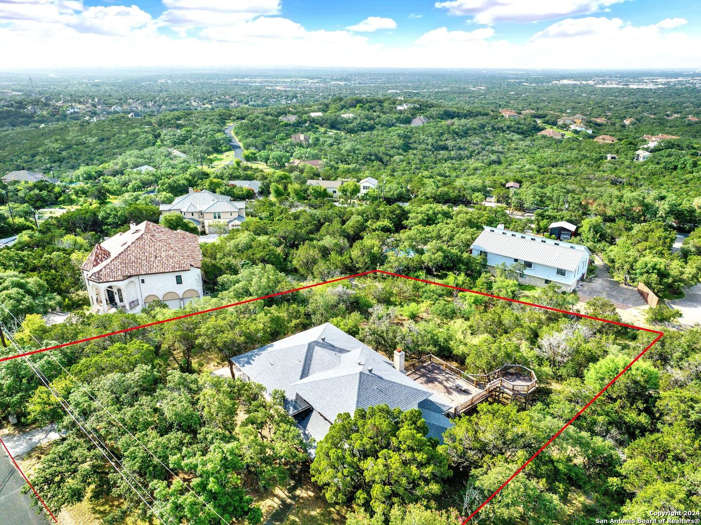 an aerial view of residential houses with outdoor space and trees