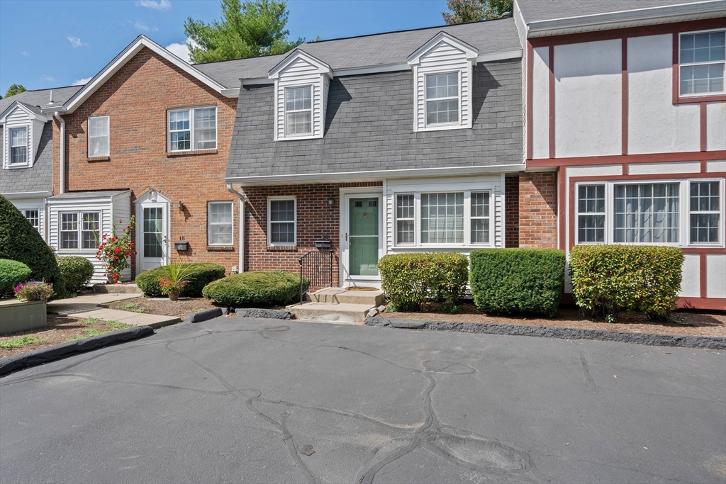 front view of a brick house with a small yard