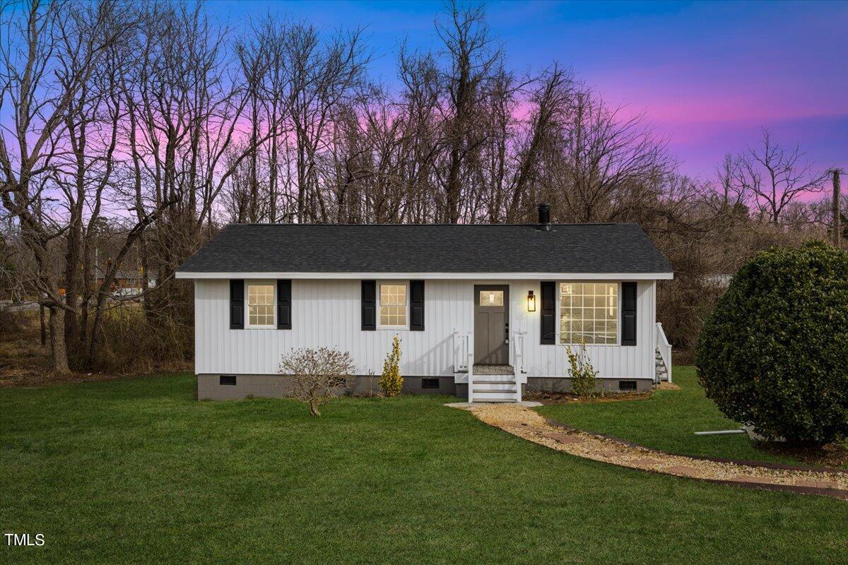 a front view of house with yard and trees