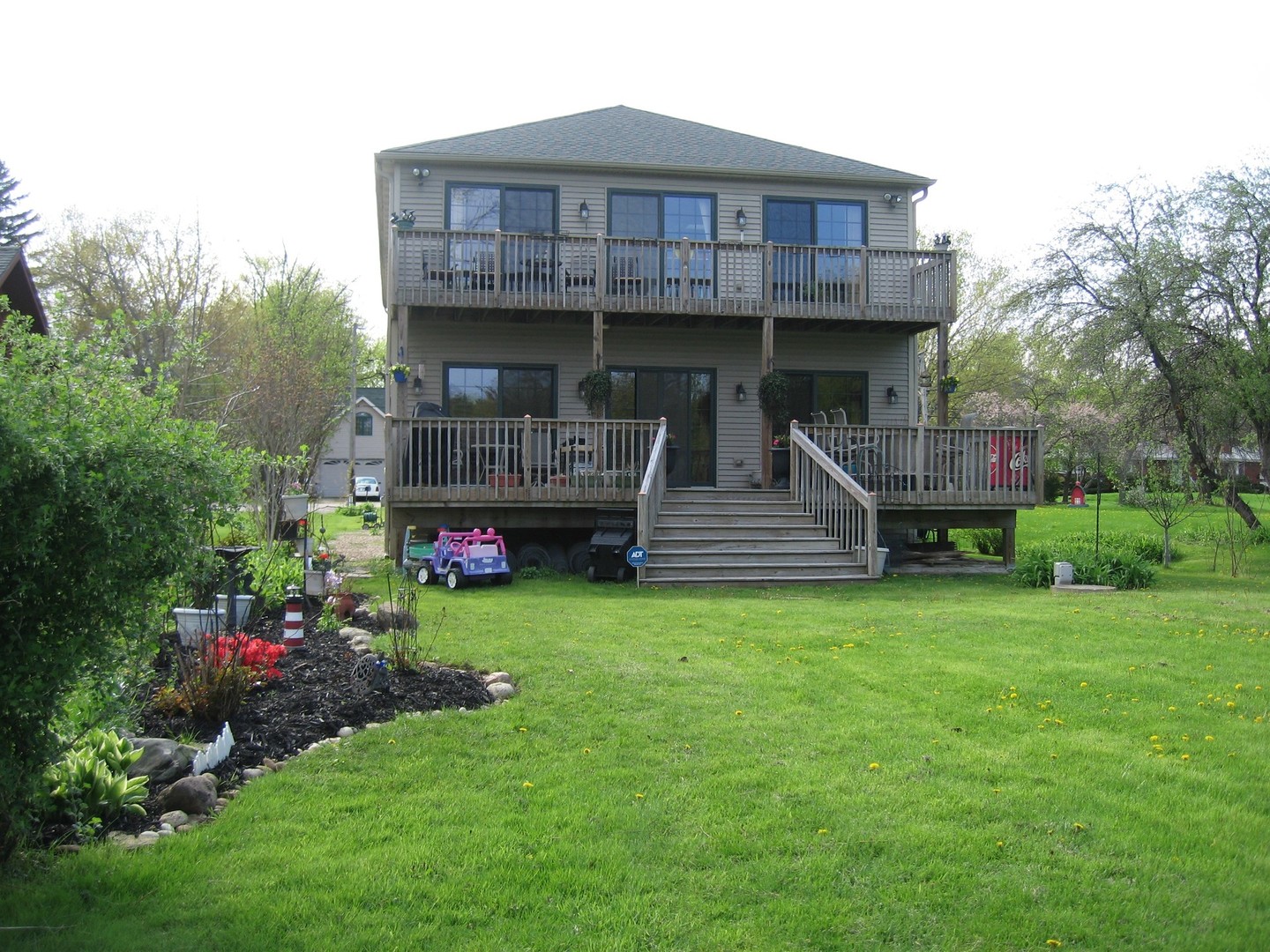 a view of a house with wooden deck and garden