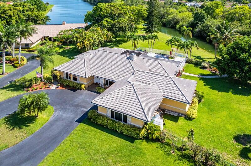 an aerial view of a house with a yard basket ball court and outdoor seating