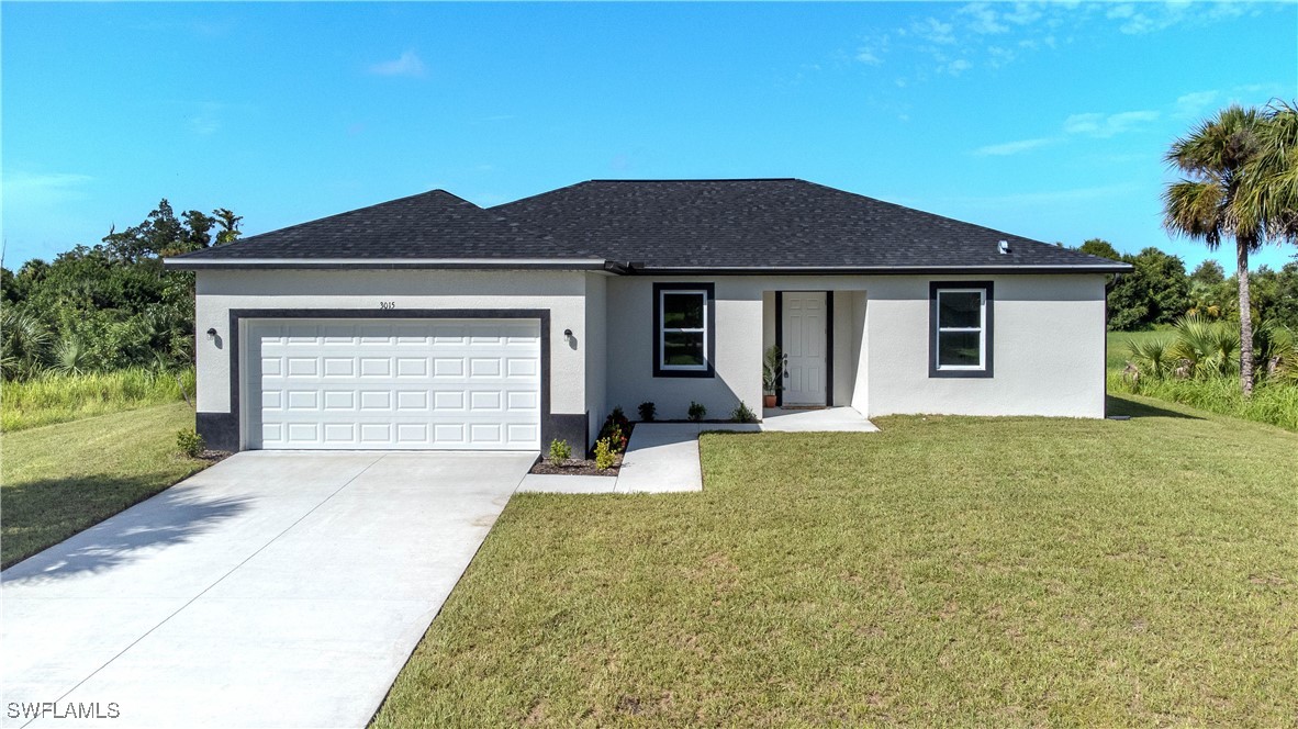 a front view of a house with yard and parking