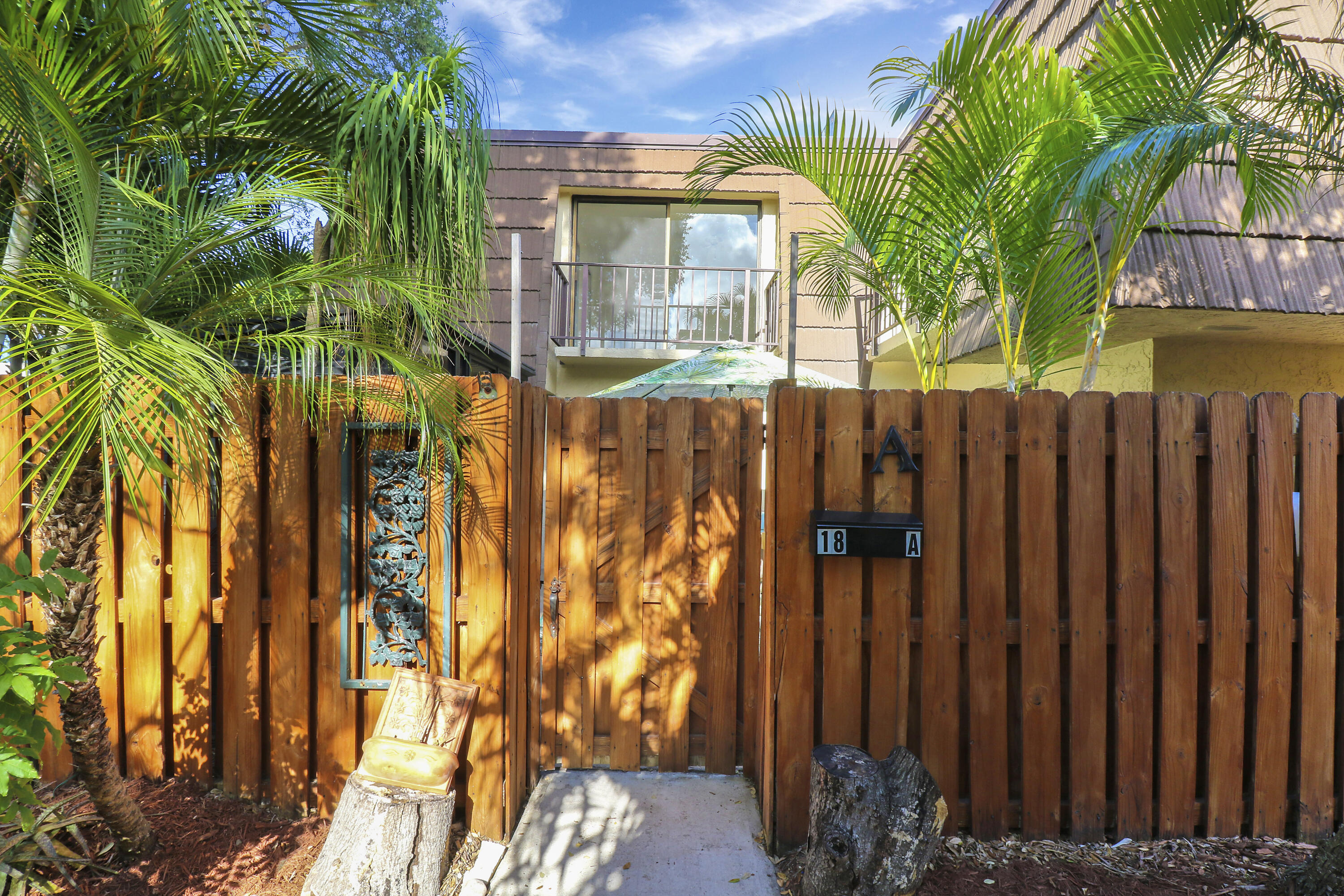 a view of a pathway of a house with a yard and potted plants