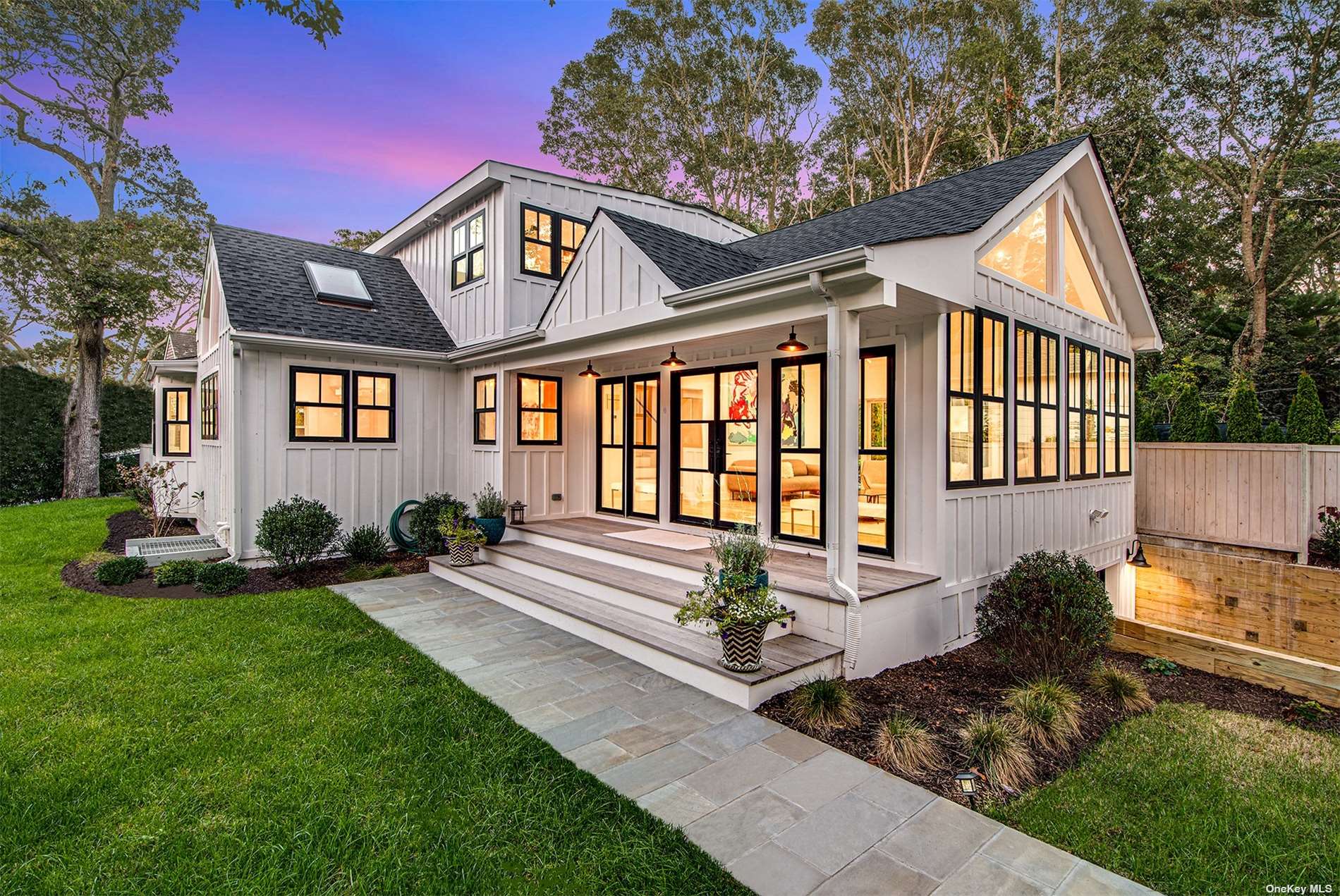 a front view of a house with a yard garden and outdoor seating