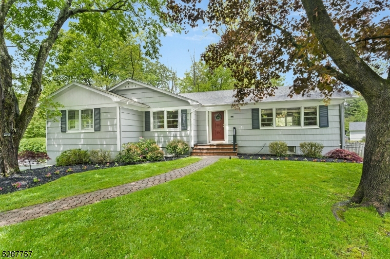 a front view of a house with a yard and trees