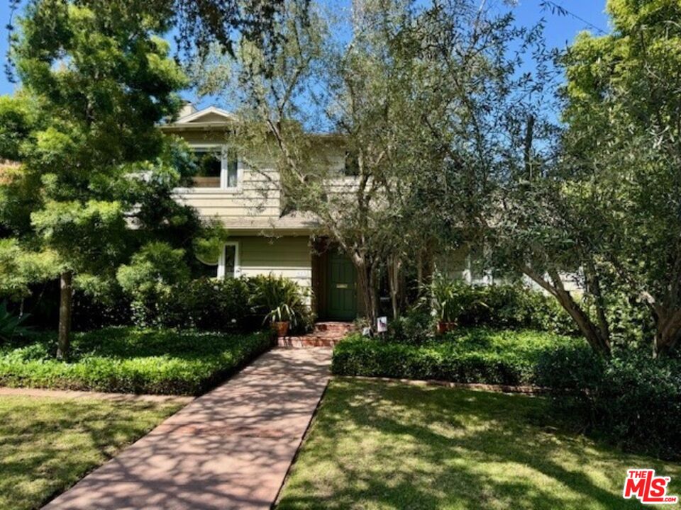 a front view of a house with a yard and green space