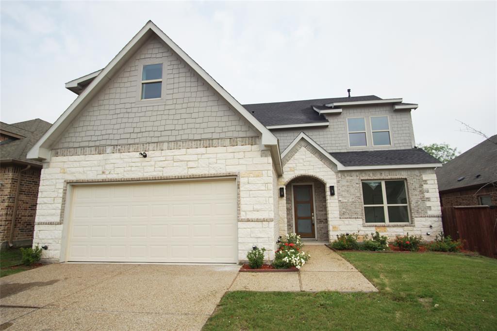 a front view of a house with a garden and garage