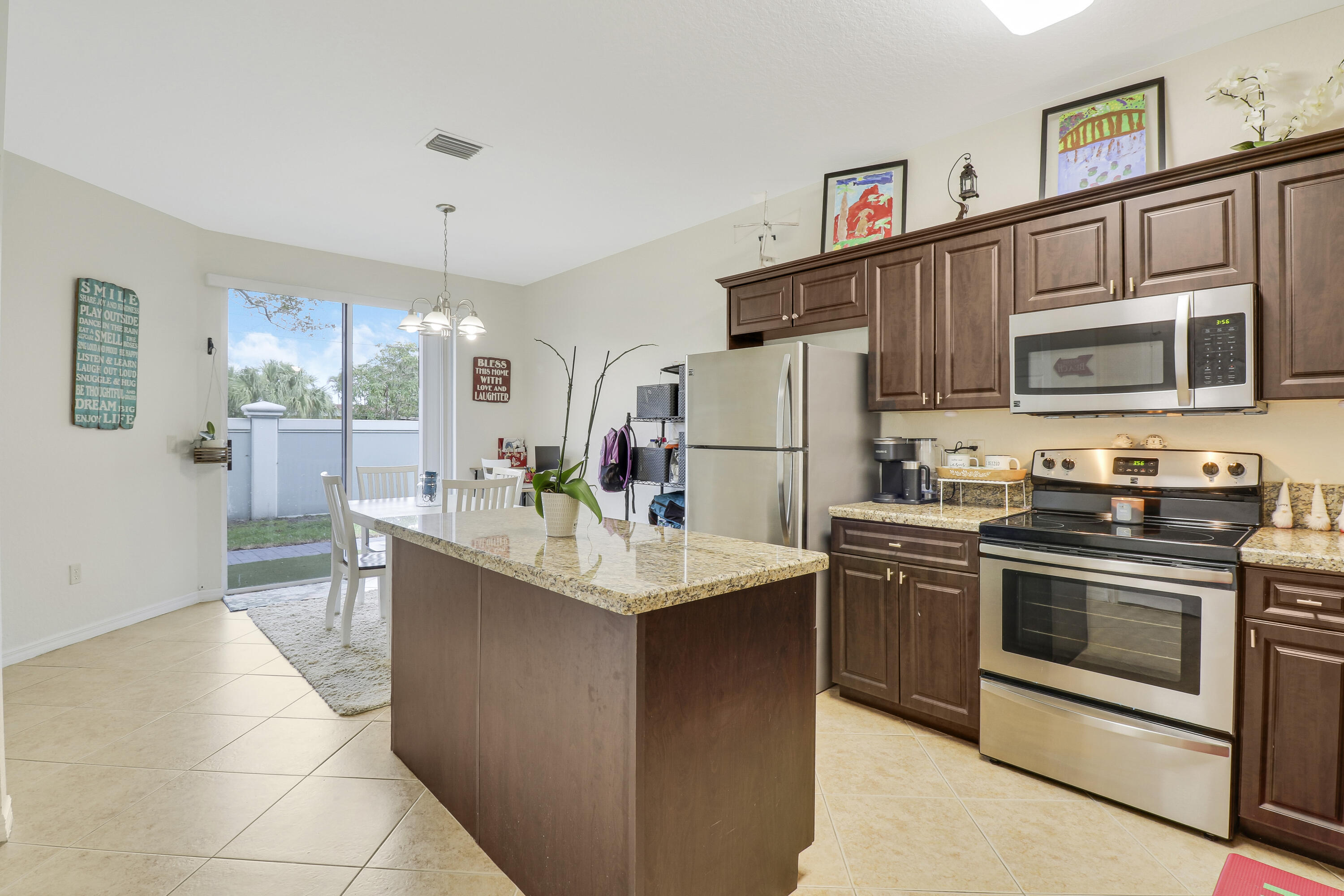 a kitchen with stainless steel appliances granite countertop a stove refrigerator and microwave