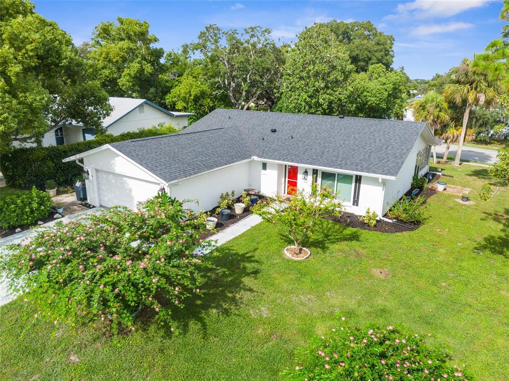 an aerial view of house with yard and trees in the background