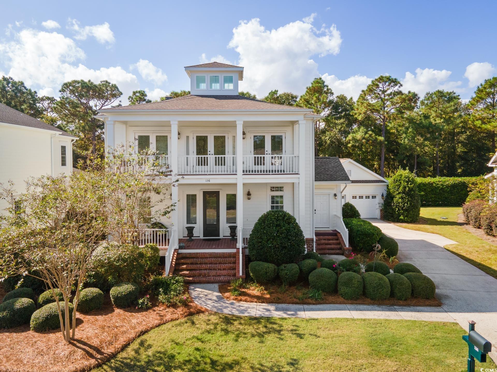 View of front facade with a porch, a garage, frenc