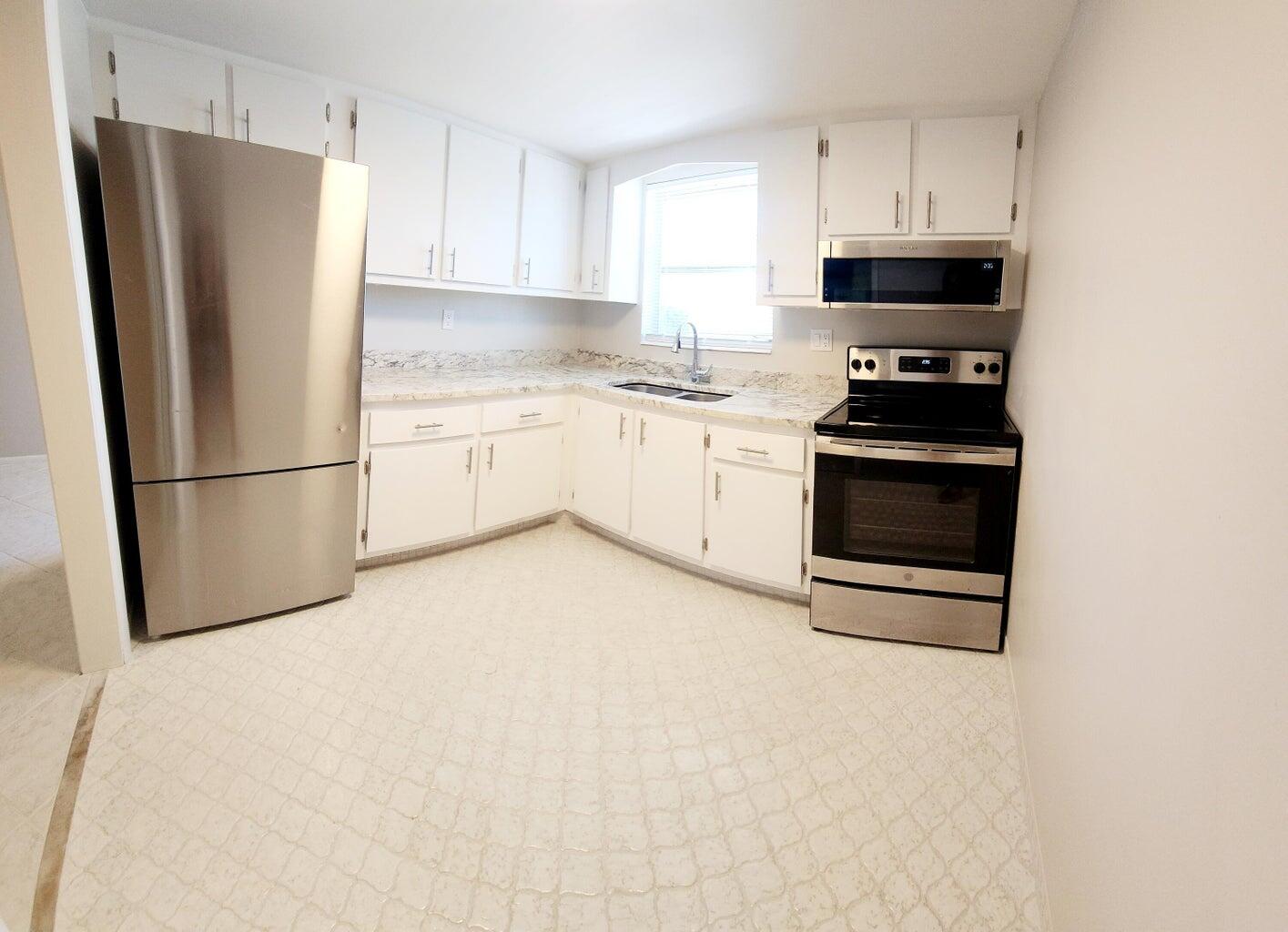 a kitchen with stainless steel appliances a refrigerator sink and cabinets