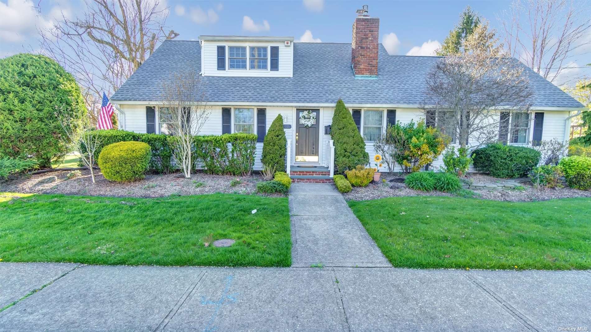 a view of a brick house with a yard and plants