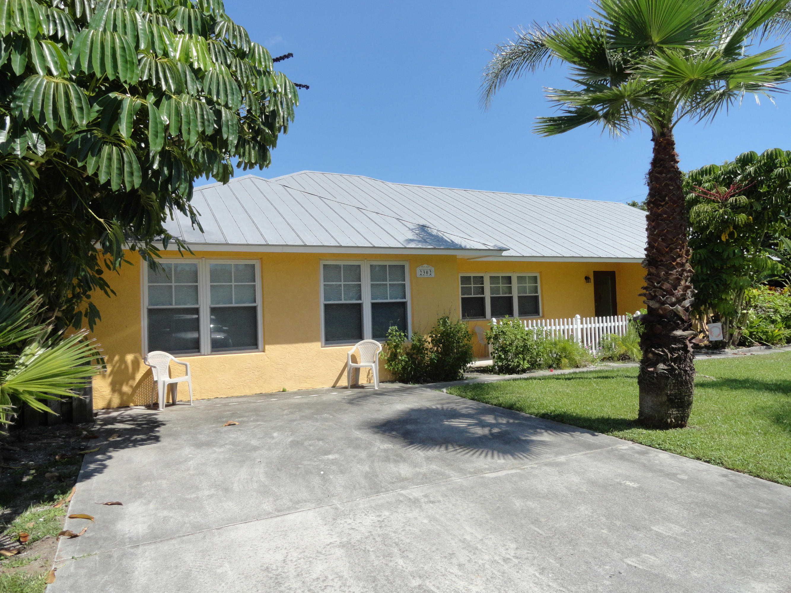 a front view of a house with a garden and yard