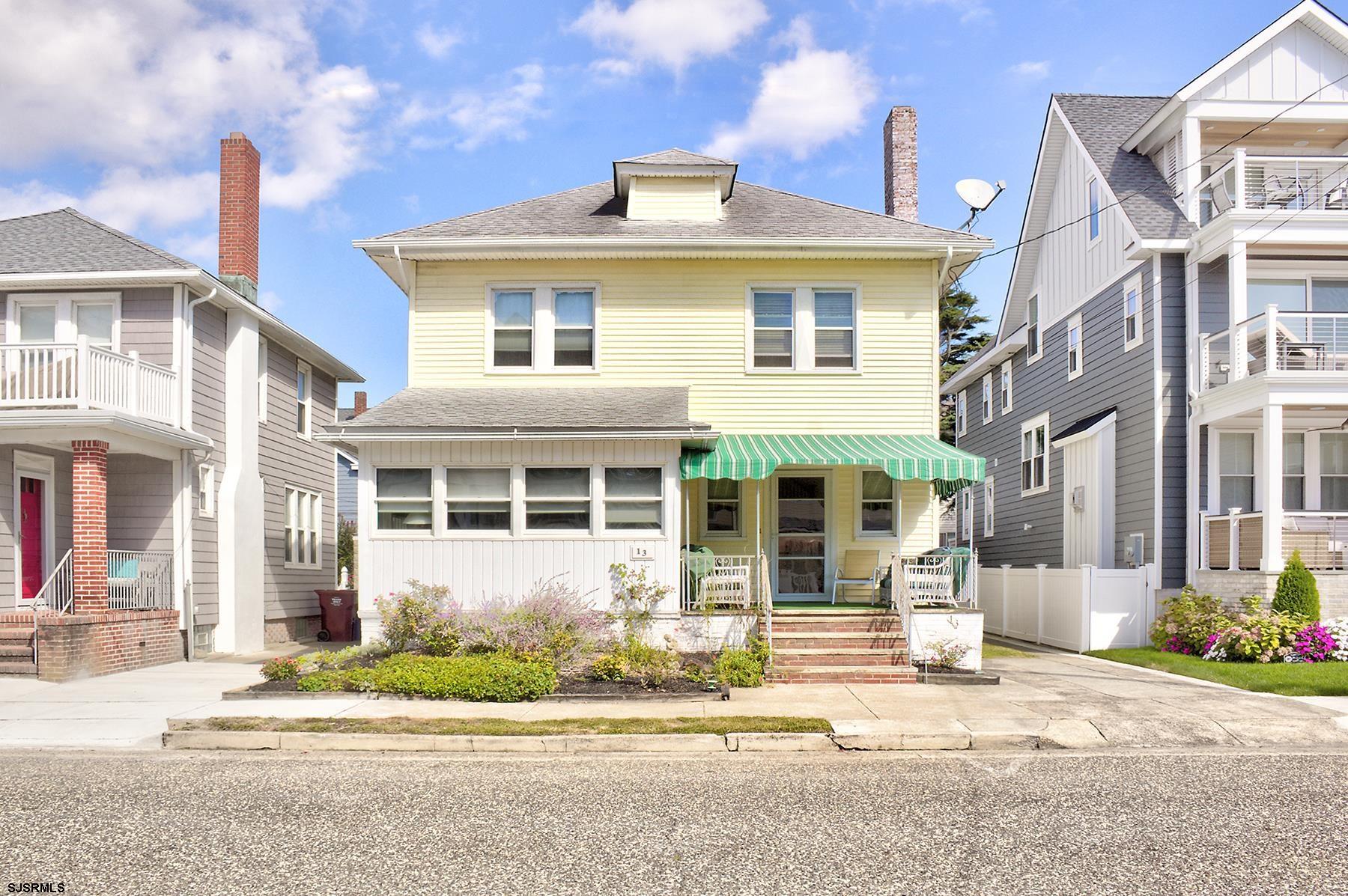 a front view of a house with a garden and plants