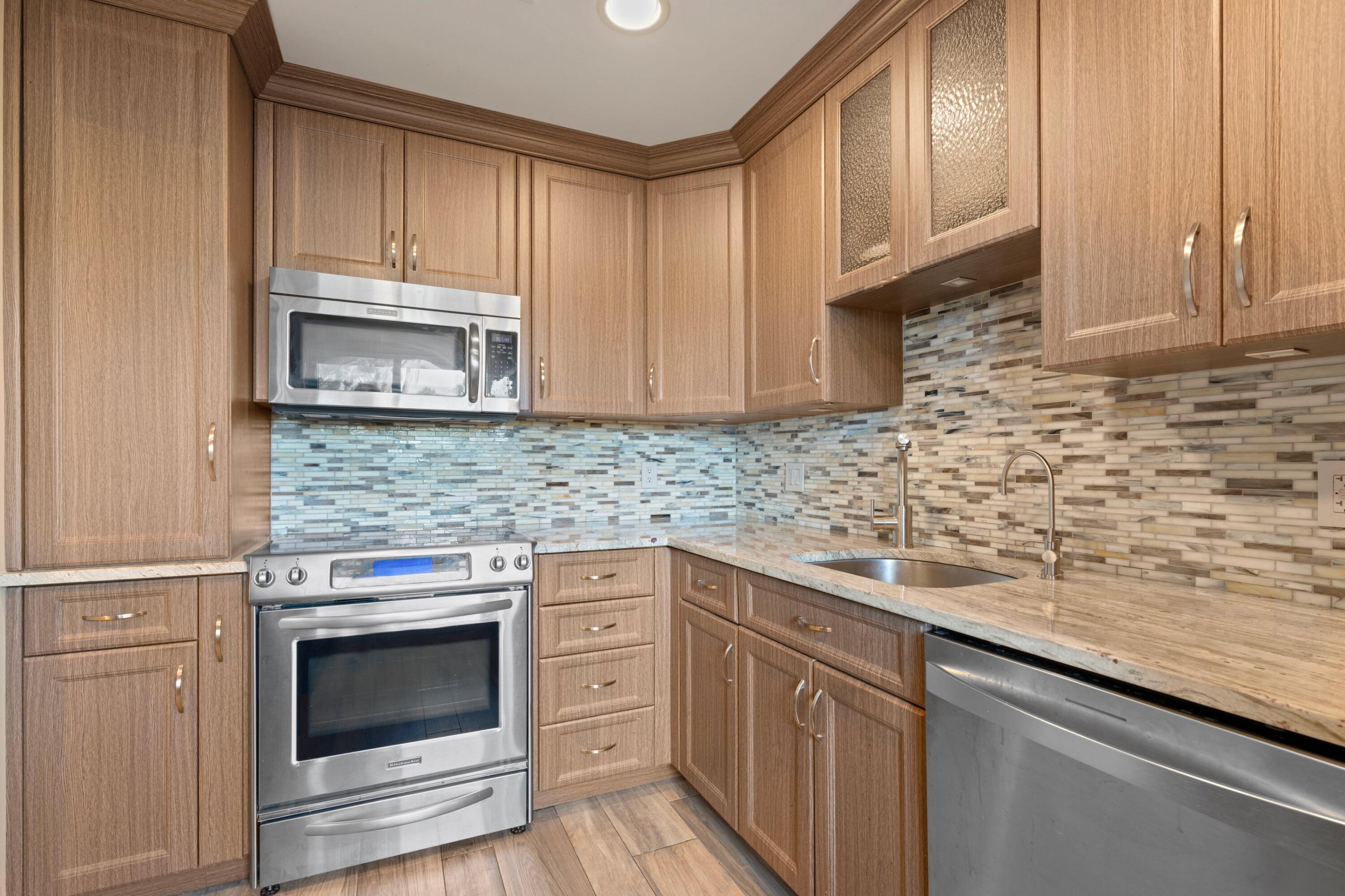 a kitchen with granite countertop cabinets stainless steel appliances and a sink