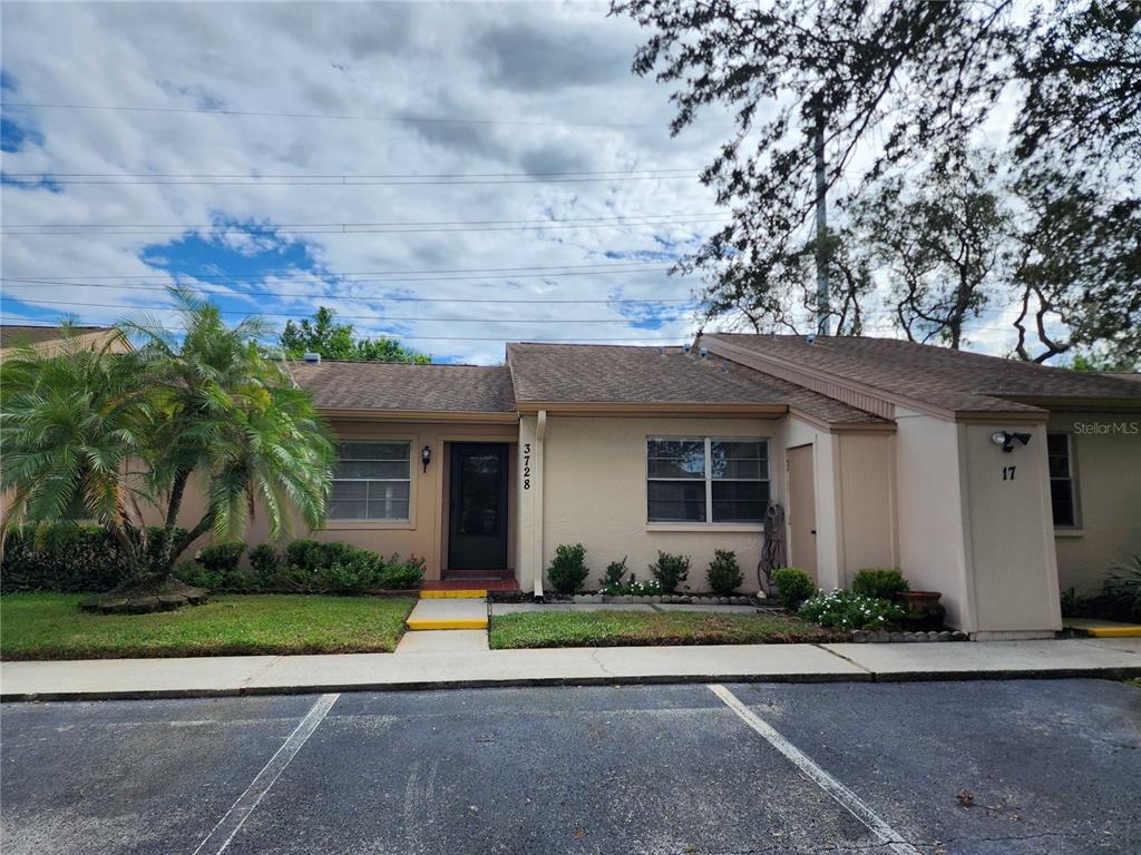 a front view of a house with a garden and palm trees