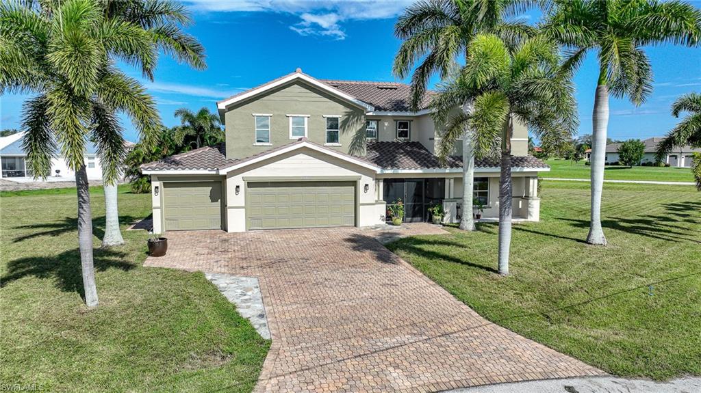 View of front of property featuring a garage and a front lawn