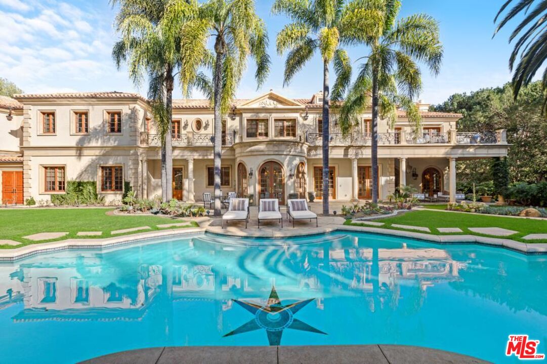 a front view of a house with swimming pool having outdoor seating