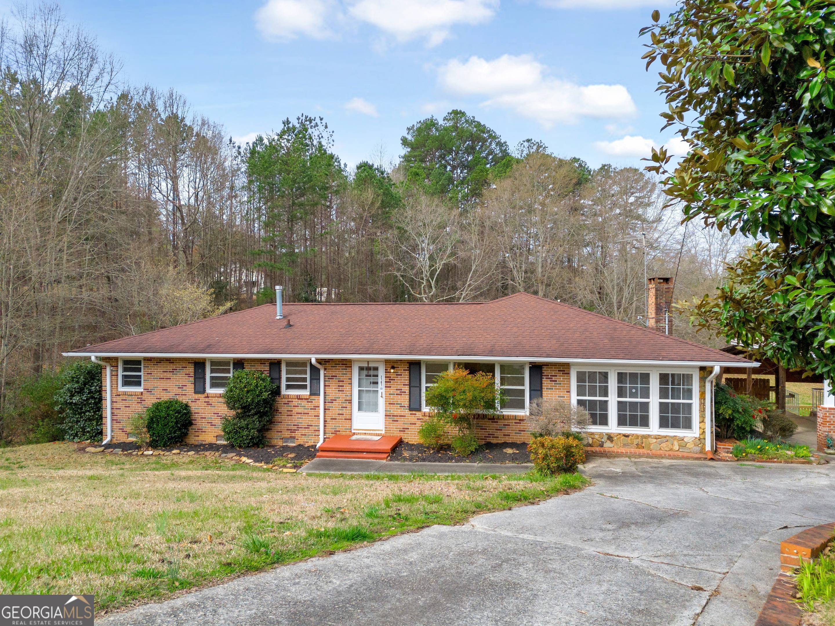 a front view of a house with a yard and trees