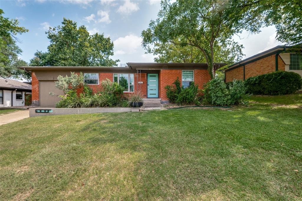 a front view of a house with a yard and potted plants