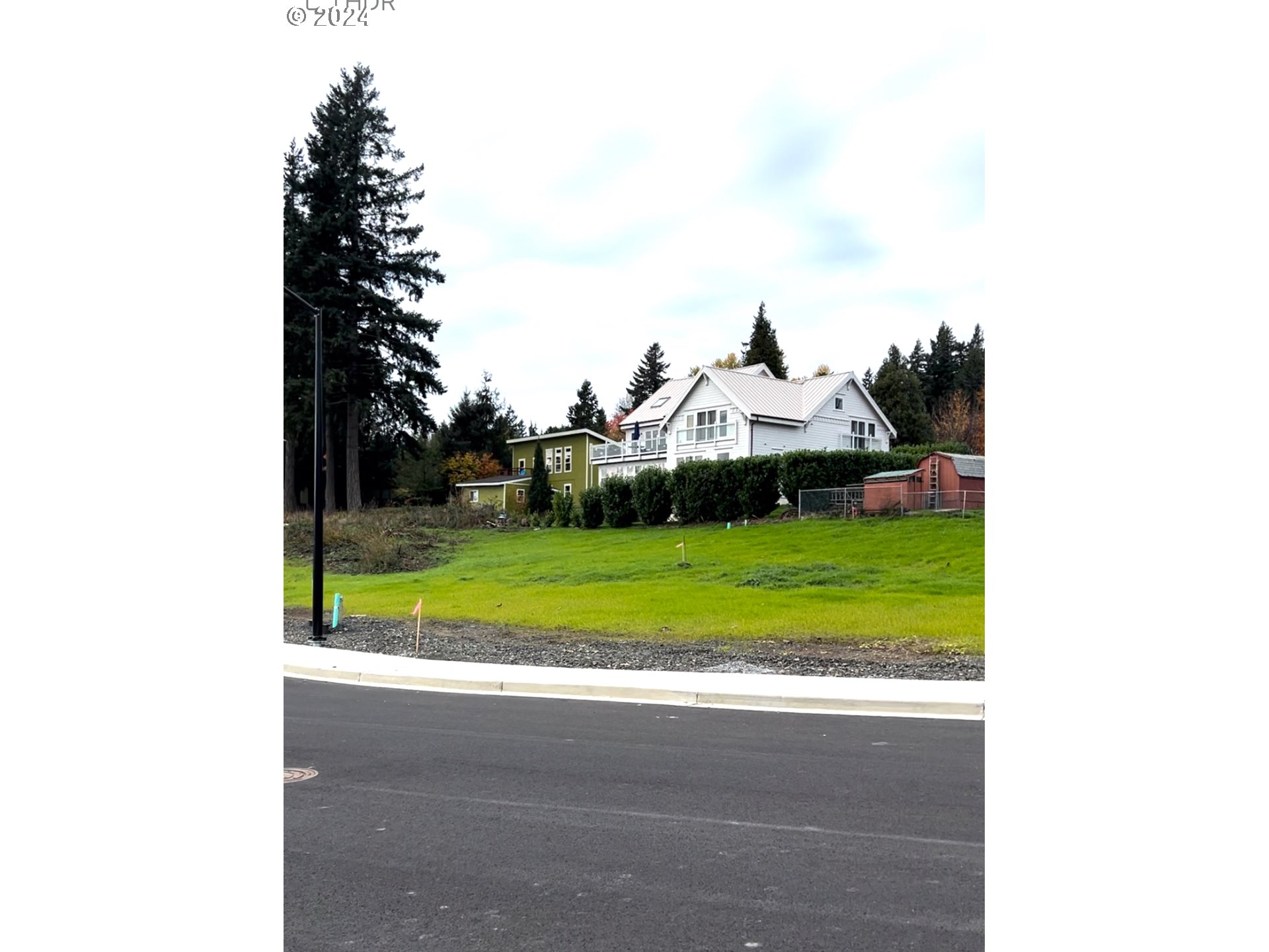 a view of a house with a big yard and large tree