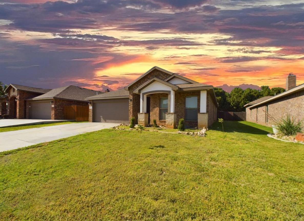 a front view of house with yard and ocean