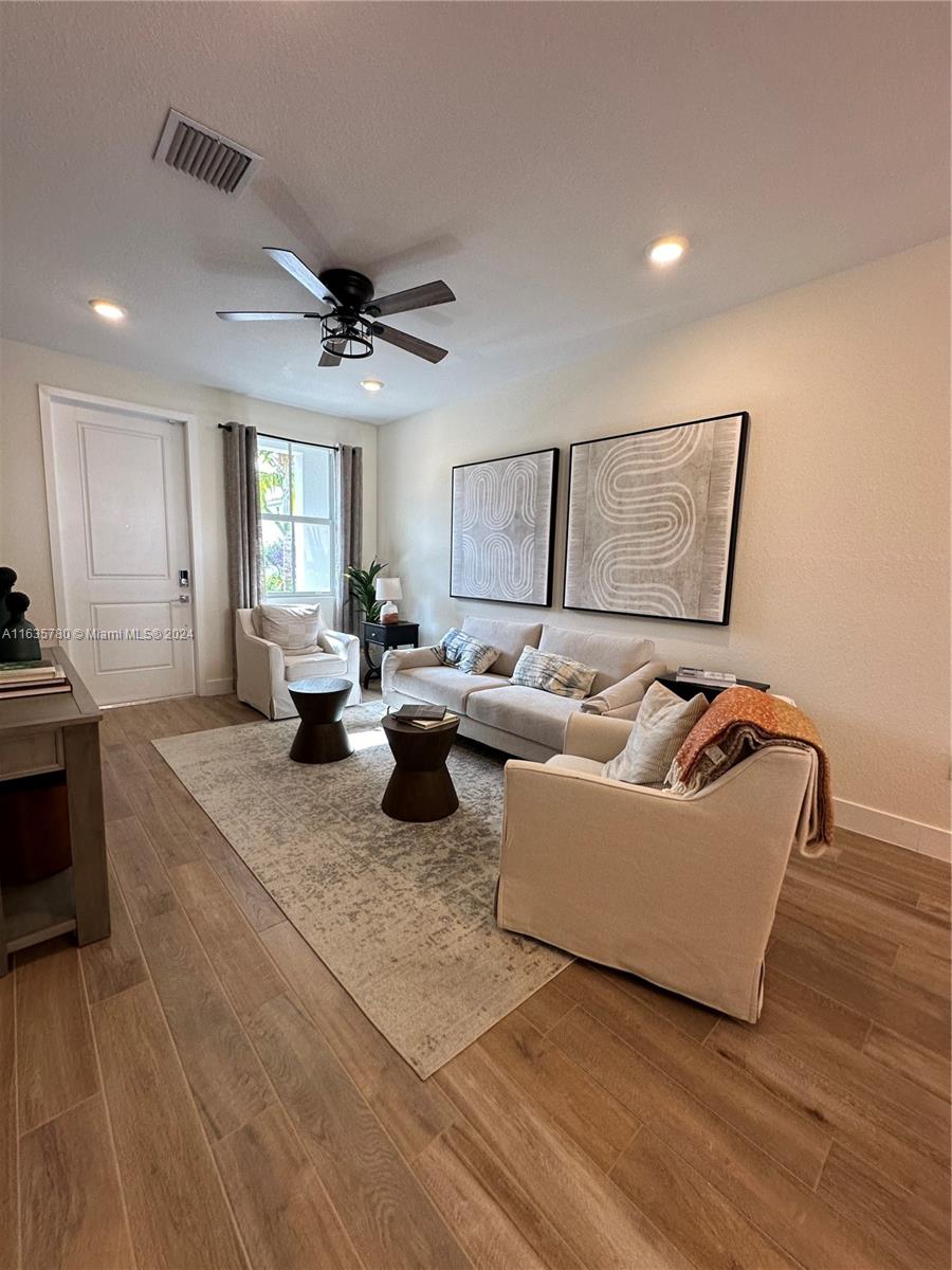 a living room with furniture and a wooden floor