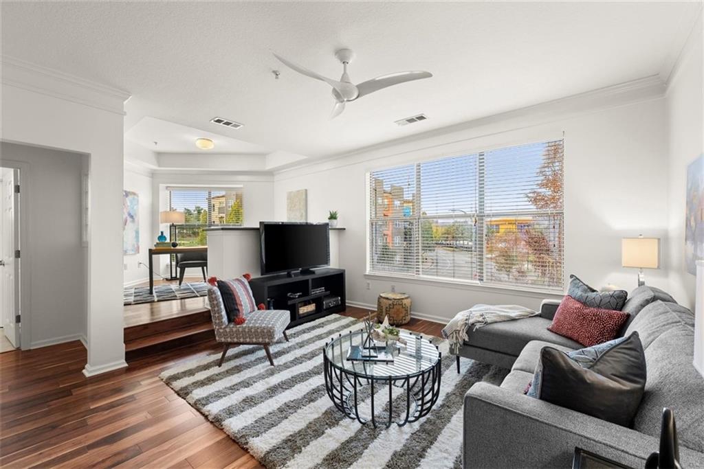 a living room with furniture a flat screen tv and a large window