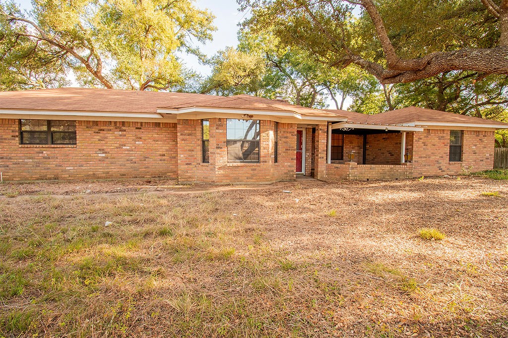 a front view of house with yard and trees around