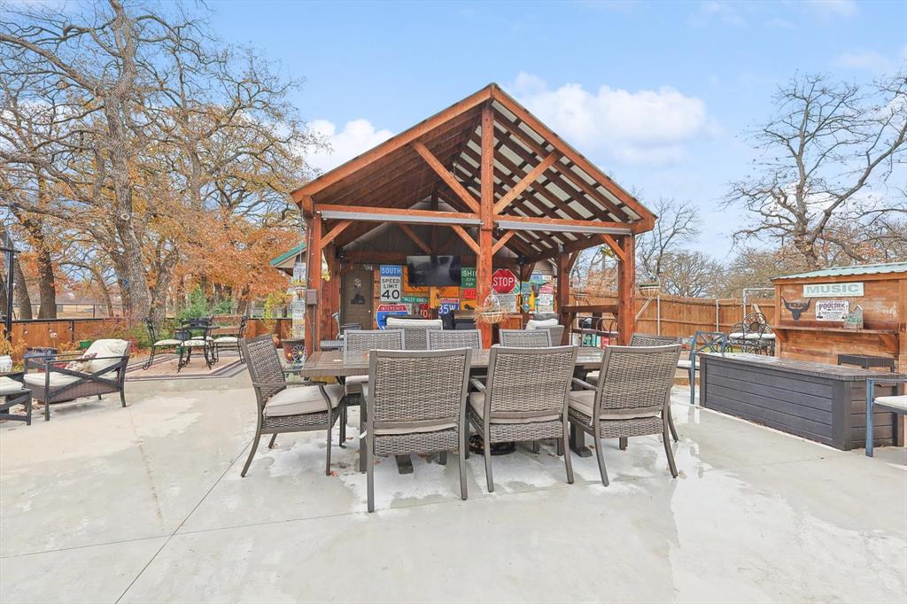 a view of a patio with dining table and chairs with wooden fence