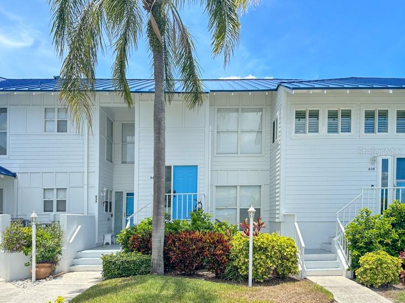 a view of a house with a yard and palm trees