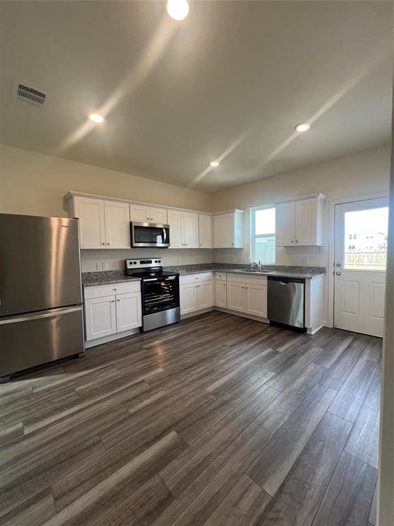 a kitchen with stainless steel appliances granite countertop a refrigerator sink and stove