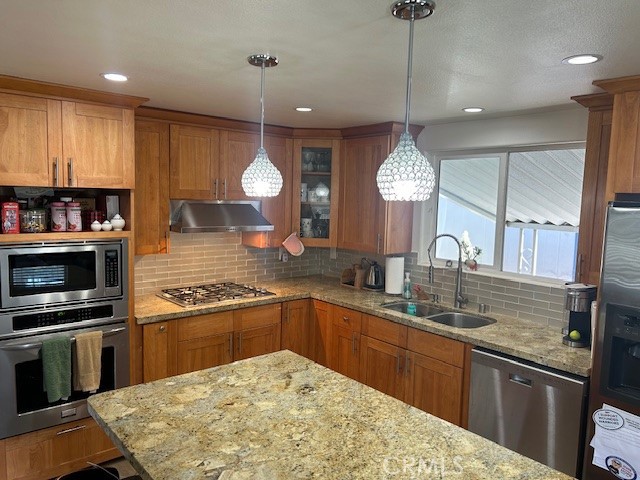 a kitchen with stainless steel appliances granite countertop a sink a stove and a wooden floors