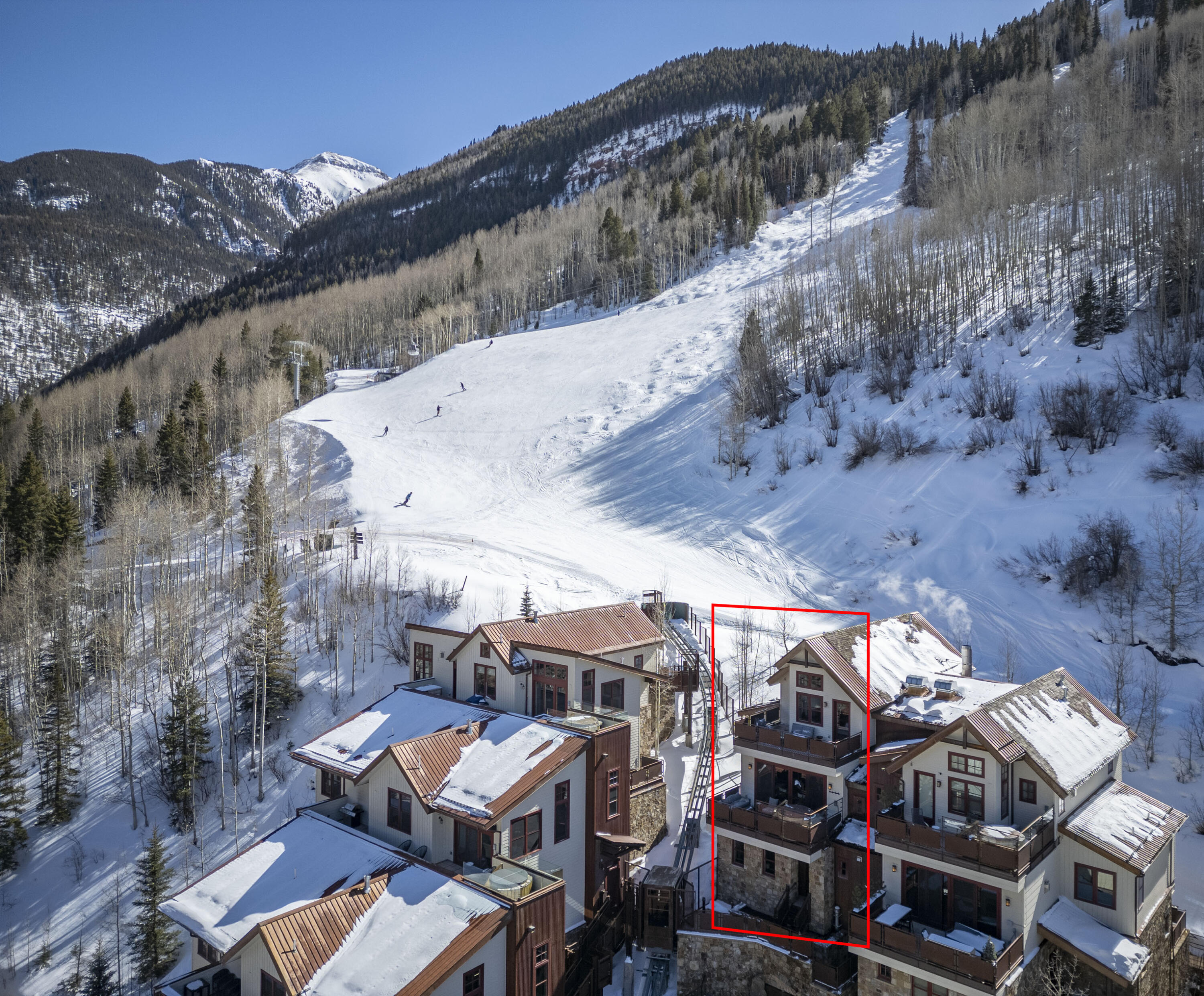 an aerial view of a house with a mountain