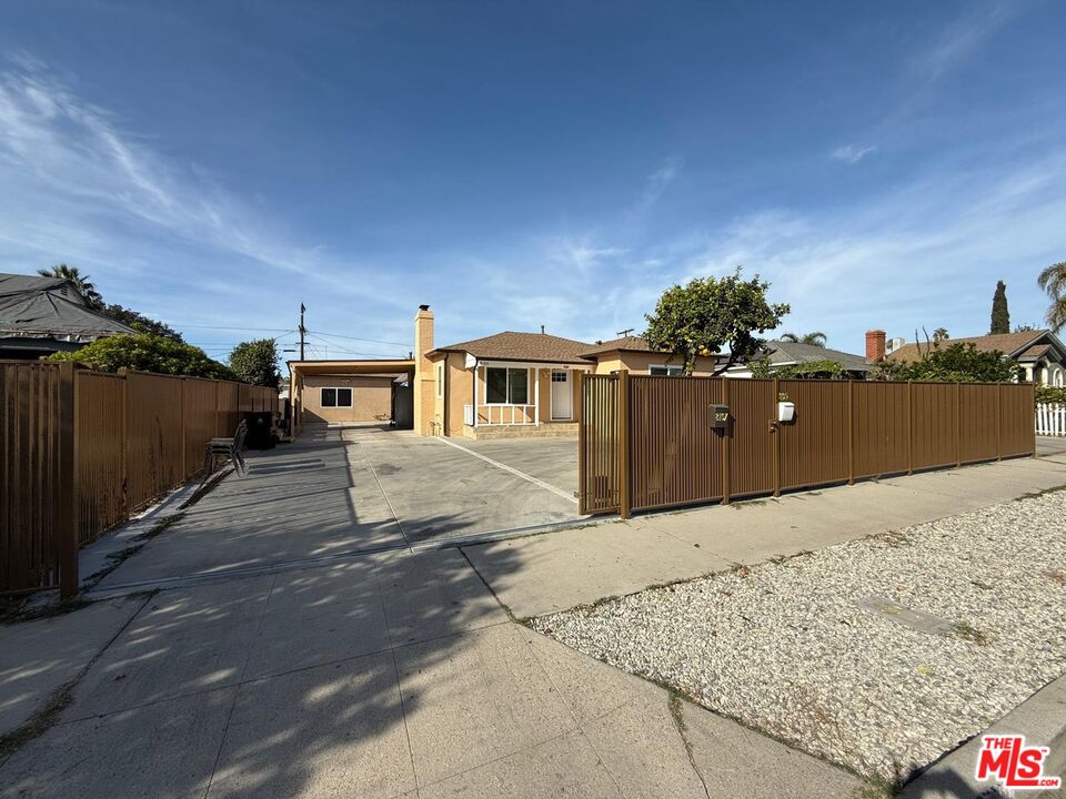 a view of a house with a wooden fence