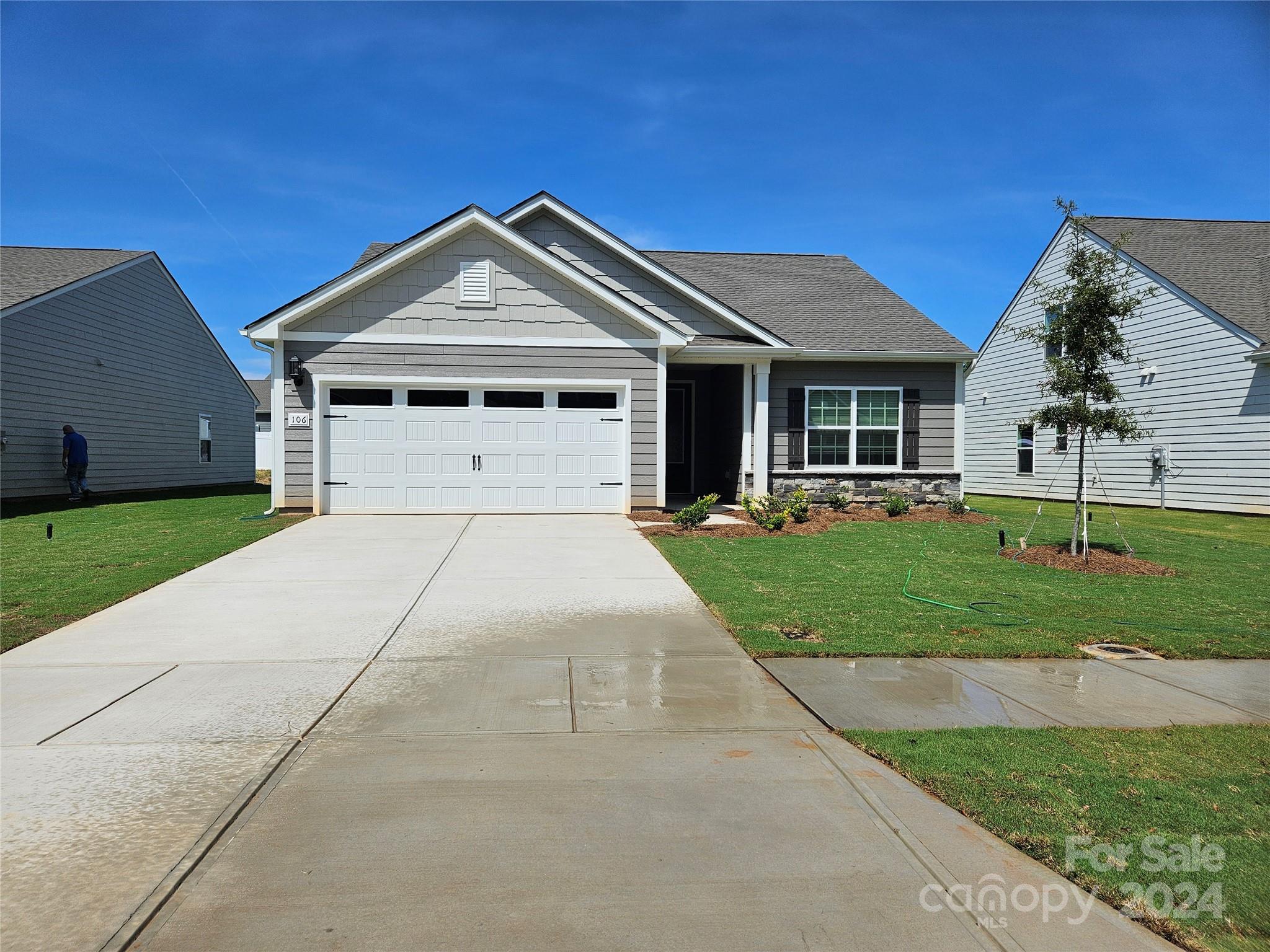 a front view of a house with a yard and trees