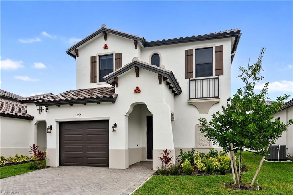 Mediterranean / spanish house featuring central AC, a front yard, and a garage