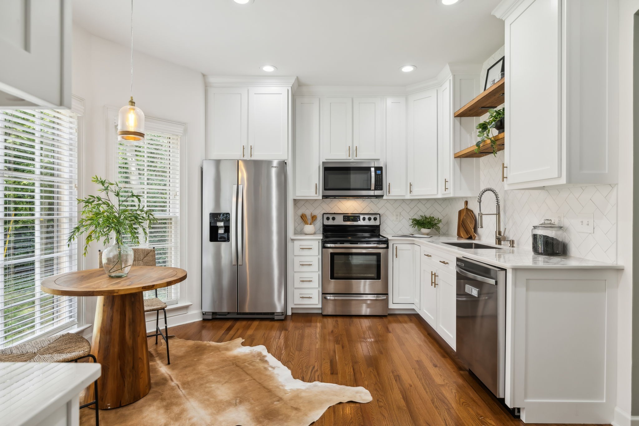 a kitchen with stainless steel appliances a stove a sink cabinets and a refrigerator