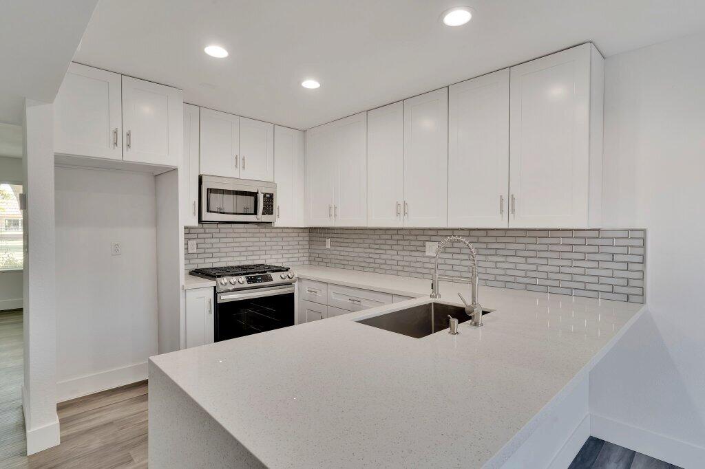 a kitchen with white cabinets and stainless steel appliances