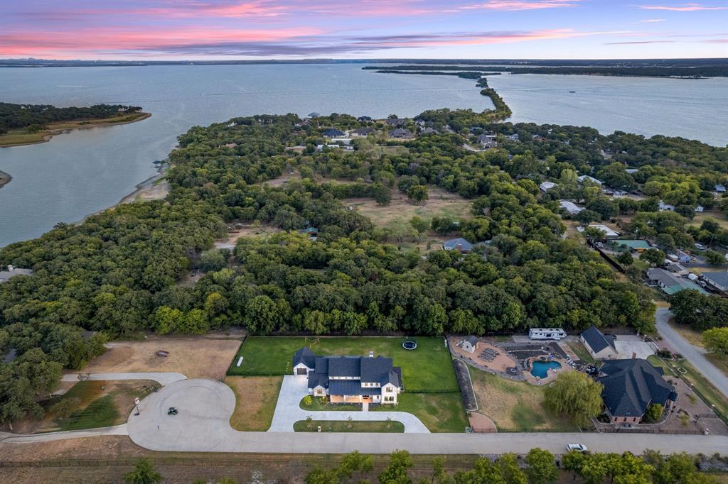 an aerial view of a house with a yard and lake view