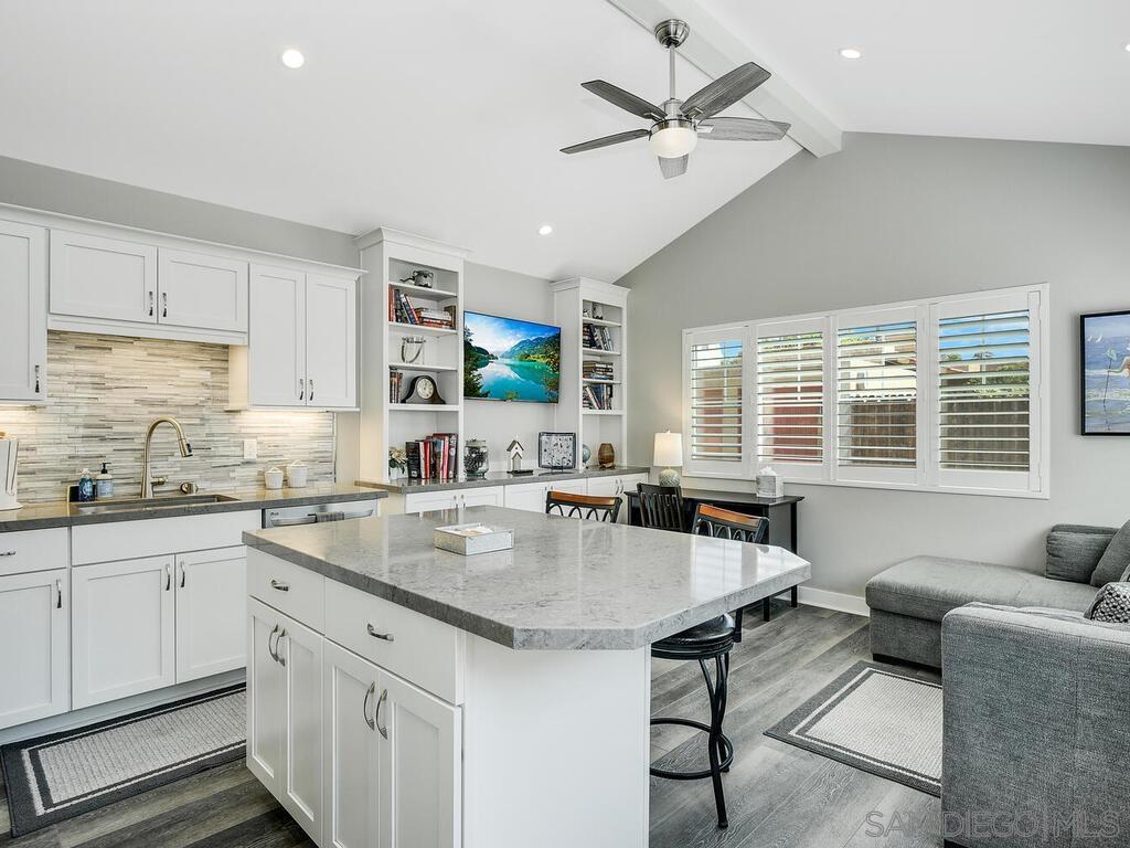 a kitchen with granite countertop a sink a counter top space appliances and cabinets