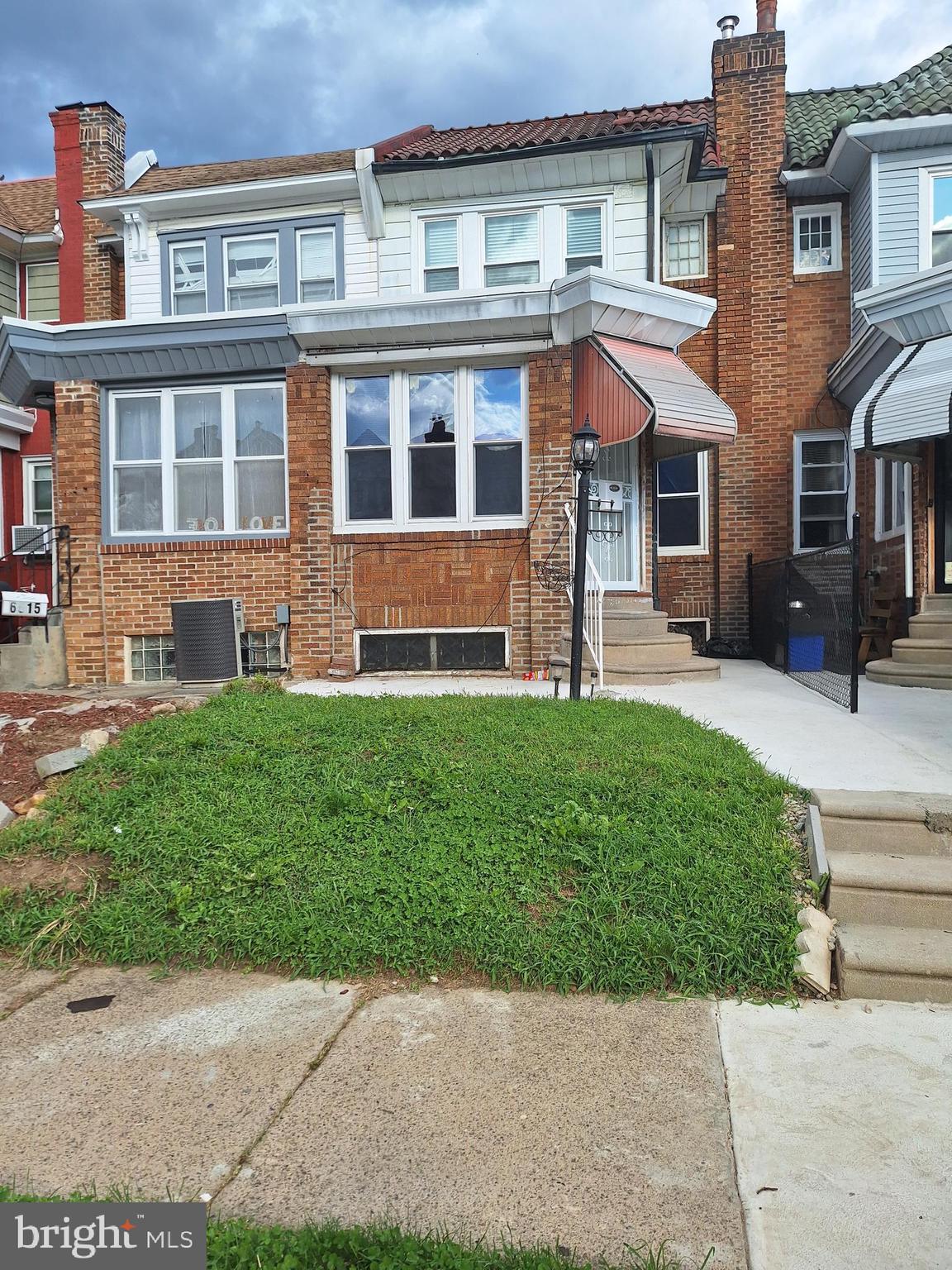 front view of a brick house with a yard