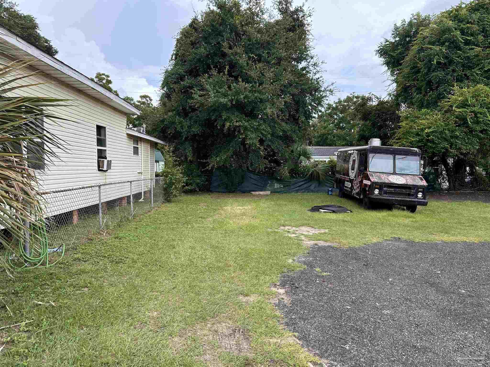 a view of a house with backyard and sitting area