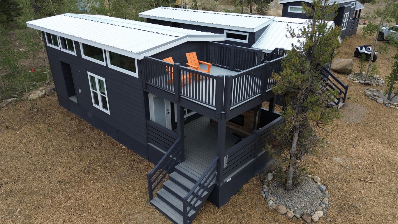 a roof deck with table and chairs with wooden floor