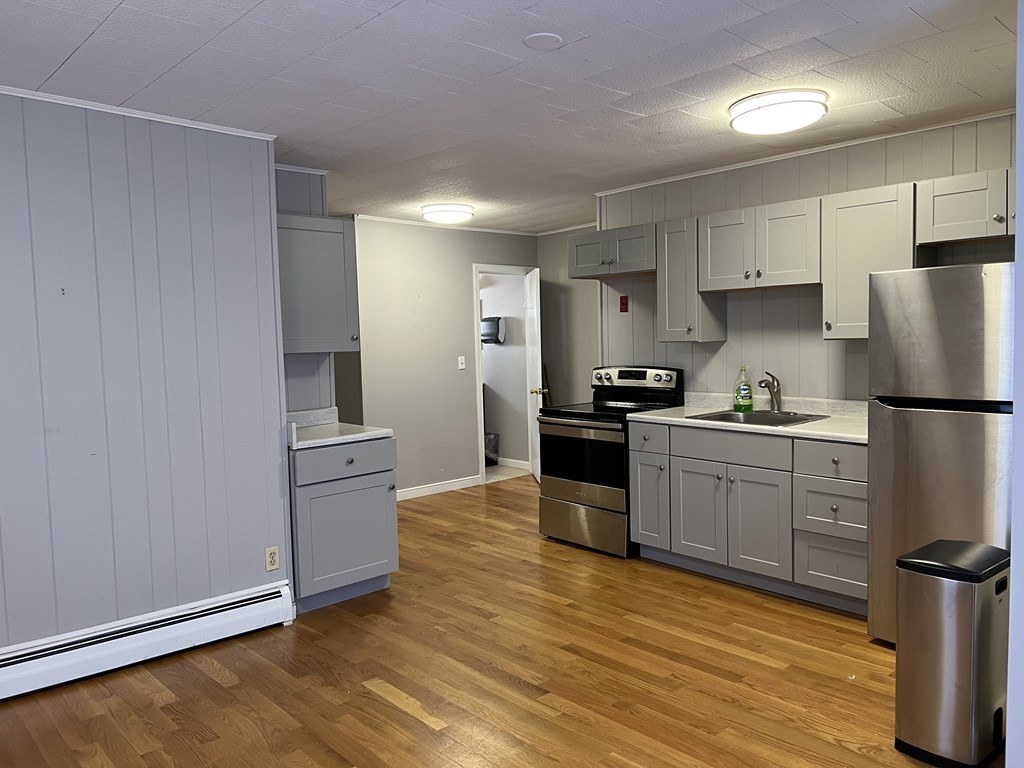 a kitchen with granite countertop a refrigerator stove top oven and sink