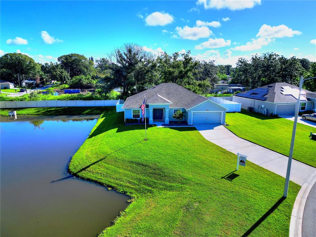 an aerial view of a house with swimming pool garden and lake view