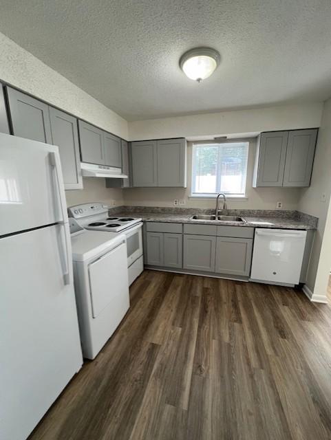 a kitchen with wooden floors and white appliances