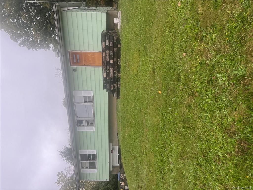 a front view of house with yard and outdoor seating